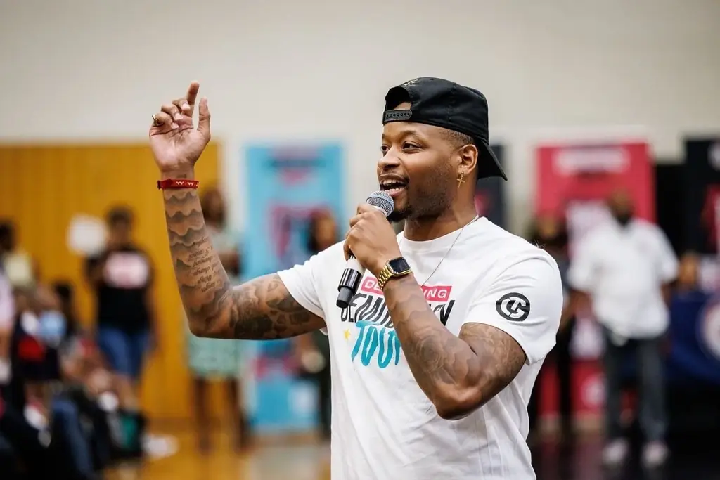 Jovan delivering a keynote in a school gym